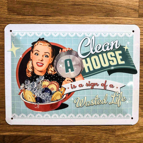 Small Metal Wall Funny Sign - 'A Clean House is the Sign of a Wasted Life' with artwork of a lady doing the dishes.
