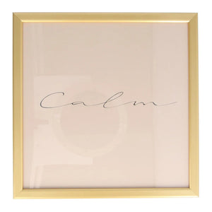 A square 'Calm' gold framed print.The word calm is in a simple black script font, across a dusky pink background. It has a simple elegant gold frame.
